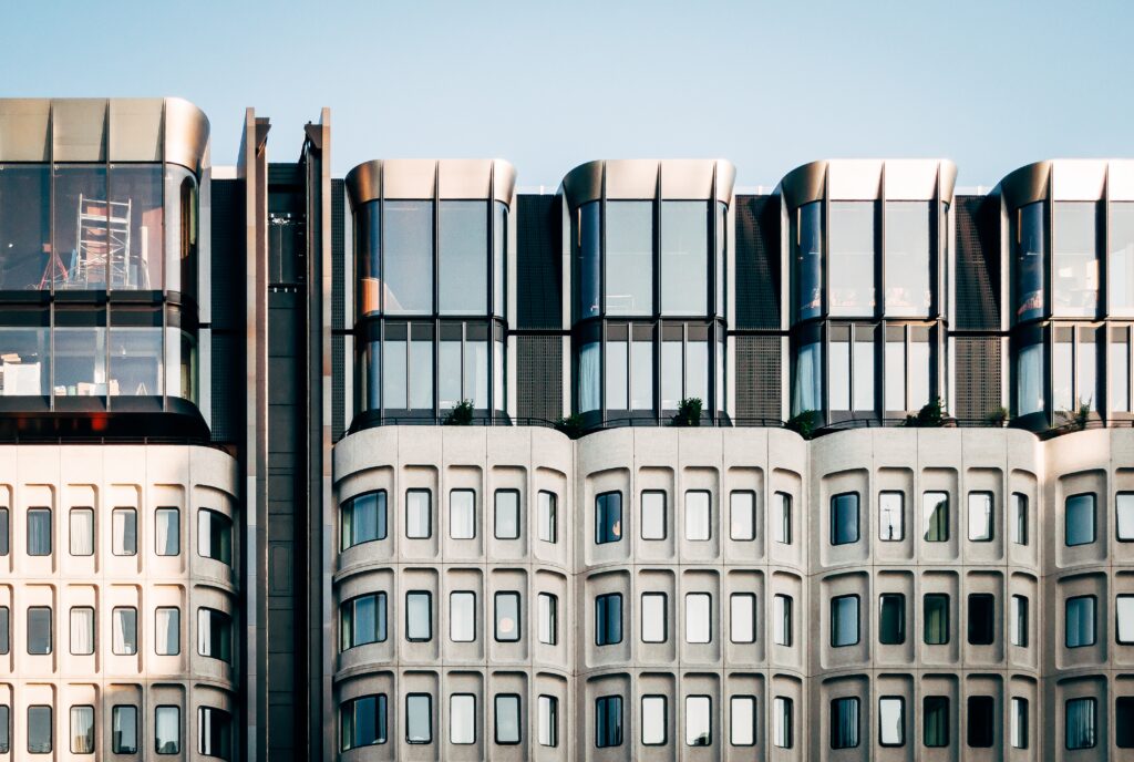 A beautiful wide shot of modern white architecture with large glass windows under a clear blue sky