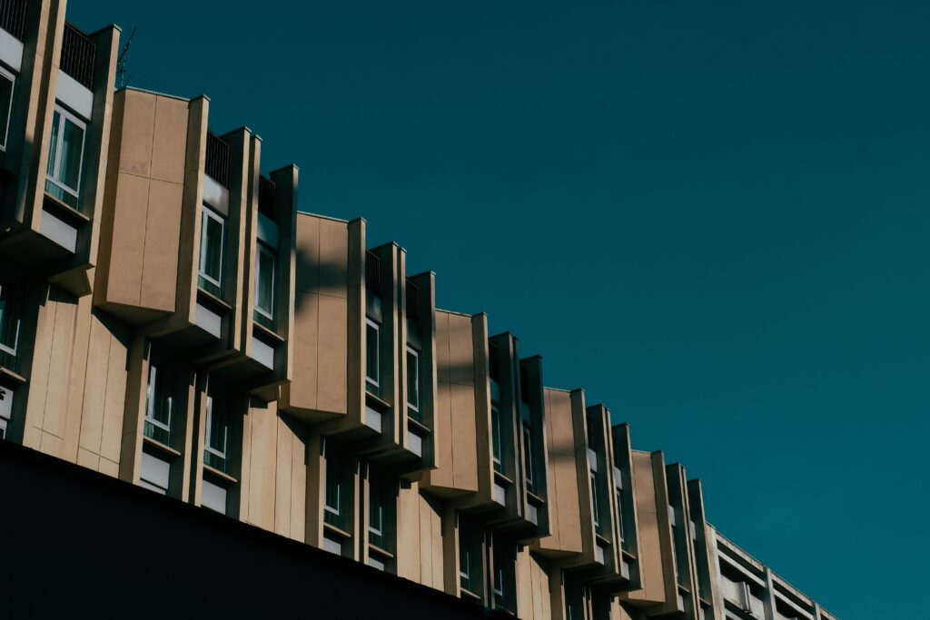 A low angle shot of a brown building with windows and a dark blue sky in the background