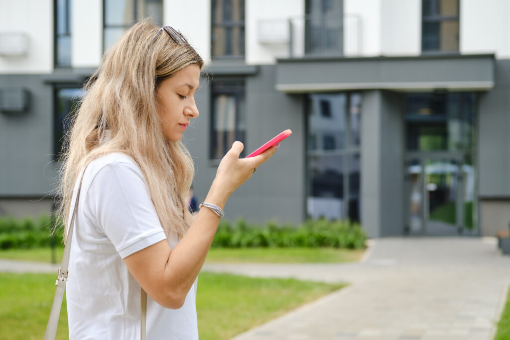 Serious woman listening to voice message on smartphone