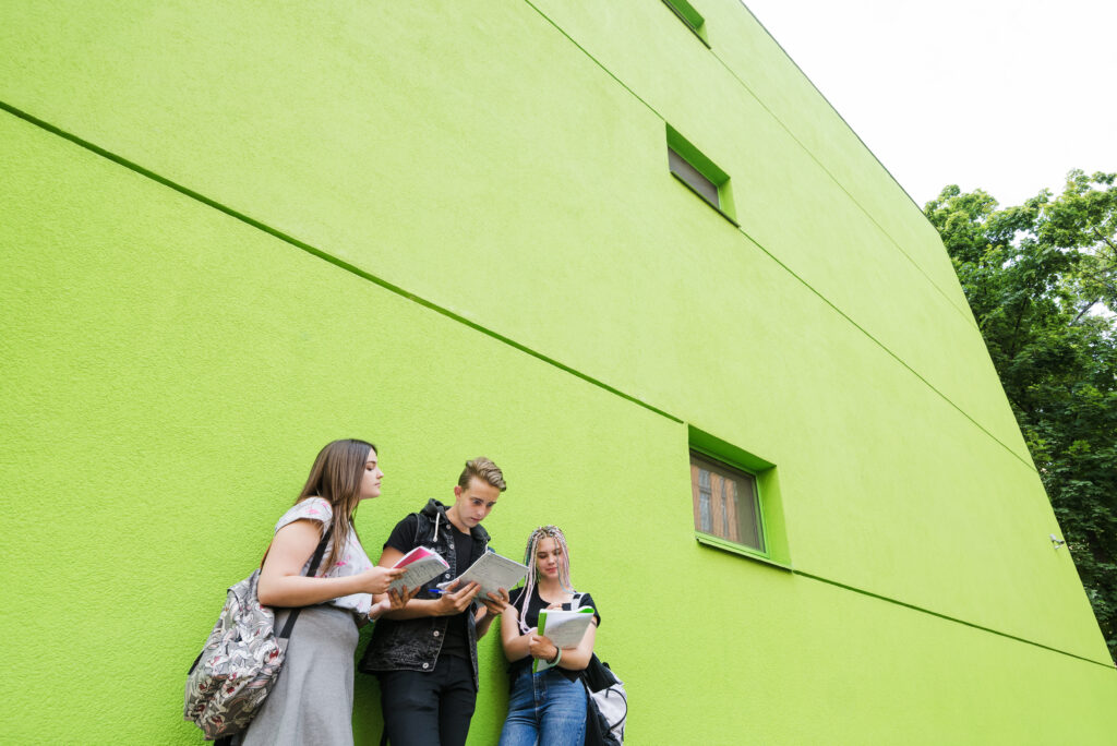 students-posing-outside-college-building